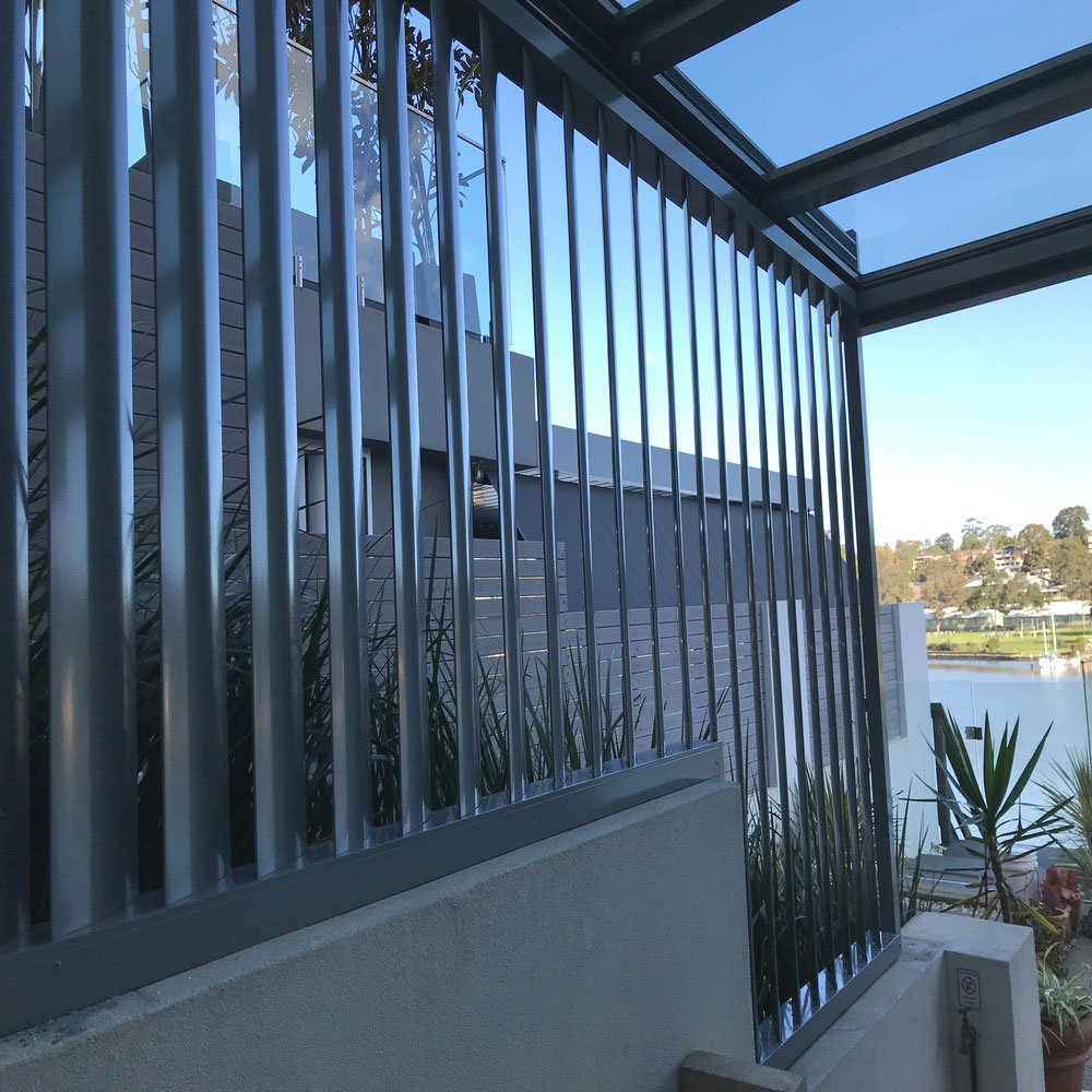 160mm fixed aluminium louvres with step-down design in waterfront BBQ area, dark grey vertical blades, Sydney