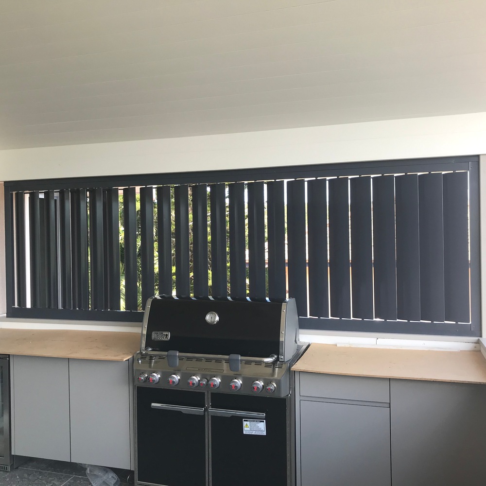 160mm vertical aluminium louvres installed behind an outdoor barbecue for privacy, airflow, and heat protection