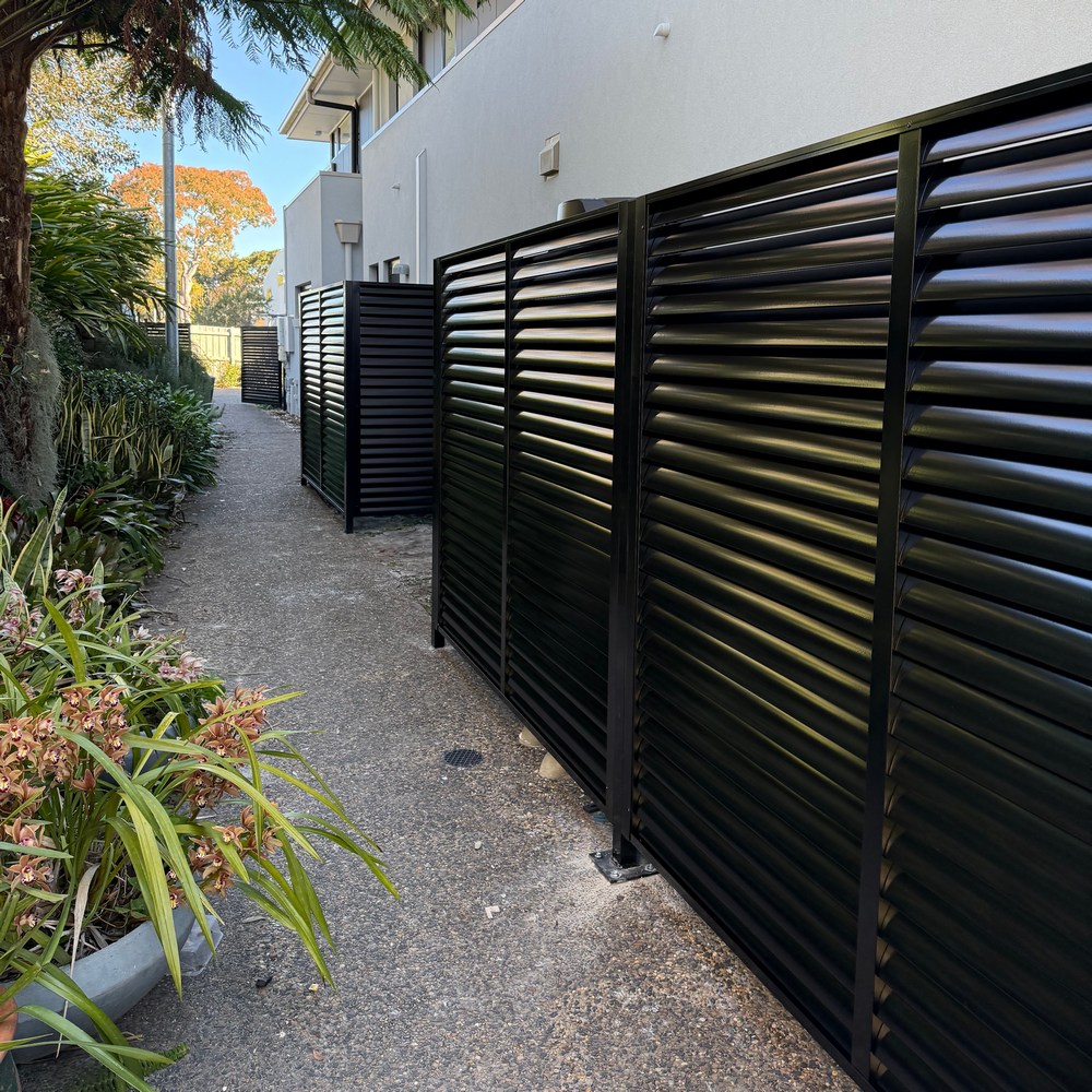 85mm aluminium louvre enclosure with integrated access gates providing privacy and airflow along a residential pathway
