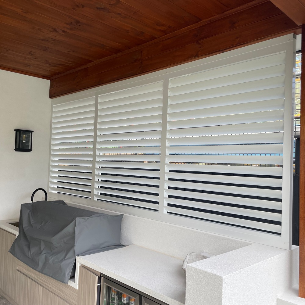 85mm adjustable aluminium louvres installed behind an outdoor barbecue for privacy and ventilation