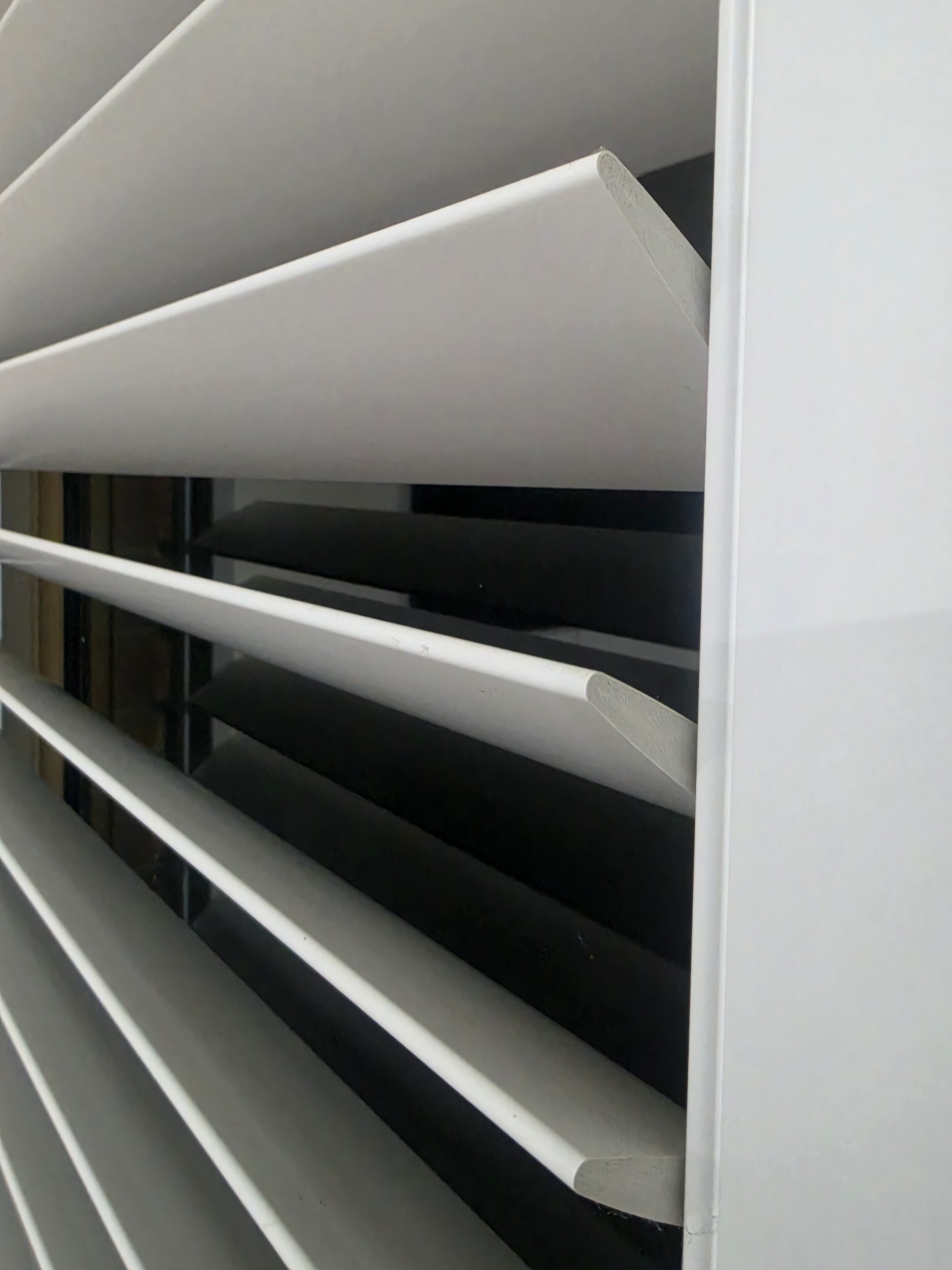 close-up of white plantation shutter blades and frame photographed from below